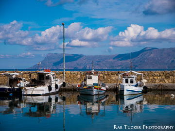 The old fishing port in Kissamos, Greece is lined with fishing boats.