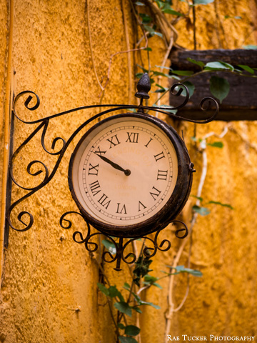 An old-fashioned clock against a yellow wall