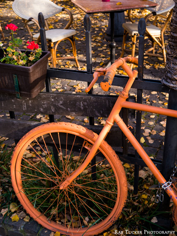 An orange-painted bicycle handles and wheel