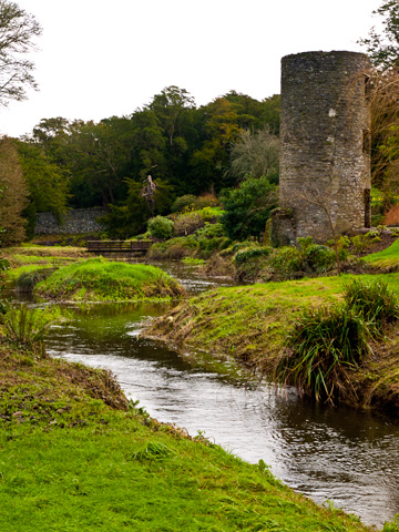 A small creek and stone tower on the grounds of the Blarney Castle in Ireland.