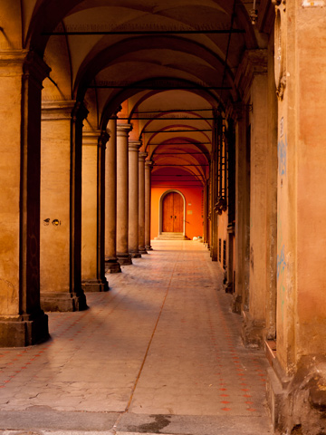 A door stands at the end of this portico in Bologna, Italy.
