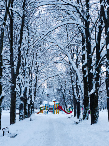 At the end of a snow covered path stands a colorful playground at a park in Sofia, Bulgaria