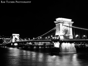 A black and white image of the Chain Bridge and Danube River at night in Budapest, Hungary