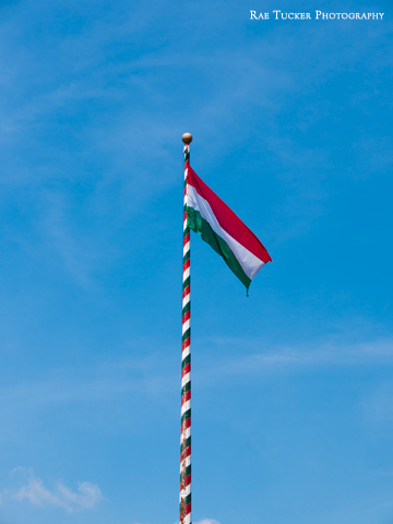The Hungarian flag a top a red, green and white flagstaff