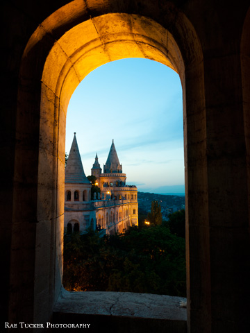 A view of Fisherman's Bastion from a window at dusk in Budapest, Hungary