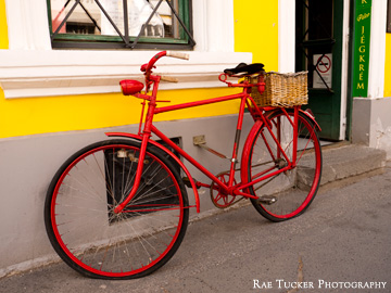 An old-fashioned red bicycle with a wicker basket