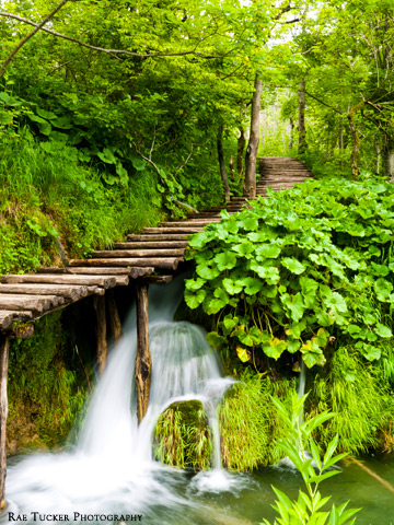 A wooden boardwalk over a waterfall in Plitvice Lakes National Park in Croatia