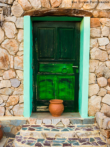 A green door on a rock wall