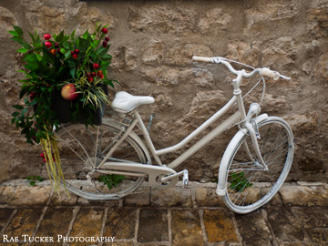 A white bicycle with a basket filled with produce in Budva, Montenegro