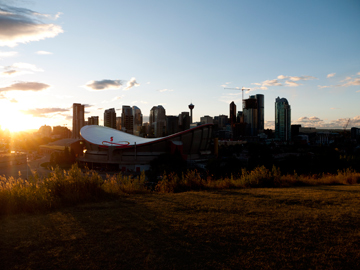As the sun sets, it illuminates downtown Calgary and the Saddeldome in Alberta, Canada.