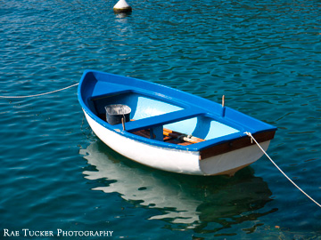 A small blue and white row boat in the Kotor Bay