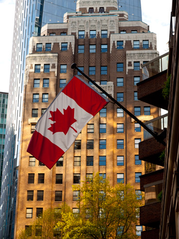 A Canadian flag and the Marine Building in Vancouver, Canada