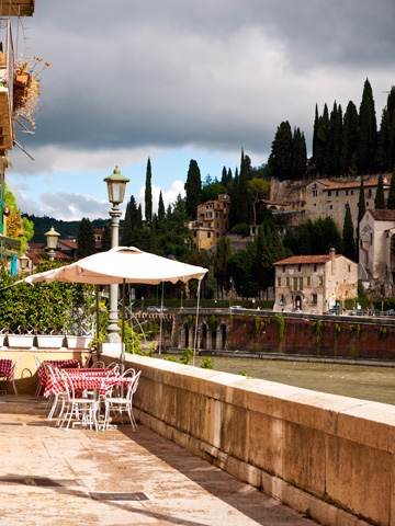 A restaurant patio in Verona overlooks the Adige river