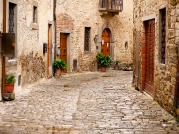 A cobblestone street and stone homes in Montefioralle, Italy