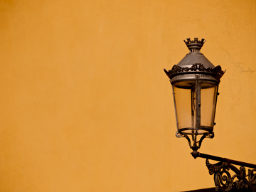 A wall lantern on a yellow wall in Parma, Italy
