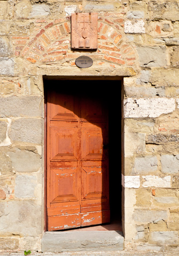 An old wooden door provides entrance to the Farneta Abbey close to Cortona, Italy