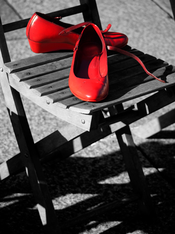 A pair of red shoes on a wooden chair