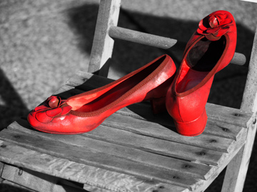 A pair of woman's red shoes on a wooden chair