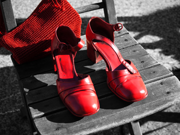 A pair of red shoes and handbag stand out on a black and white background