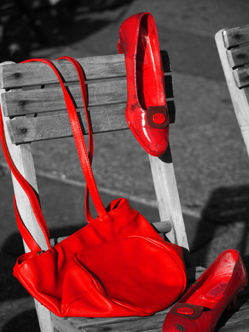 Red shoes and a red purse on a black and white background.