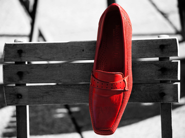 A red shoe on a black and white, wooden chair