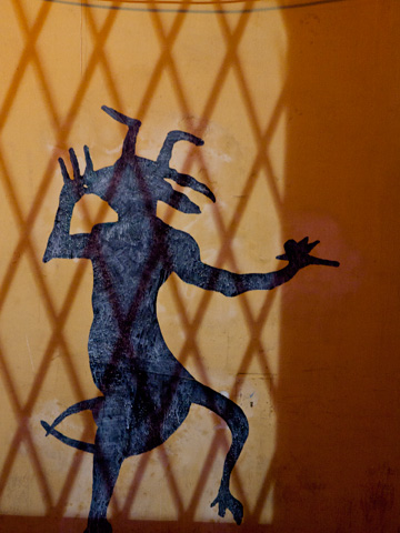 An illuminated devil is painted on a wall in Bologna, Italy