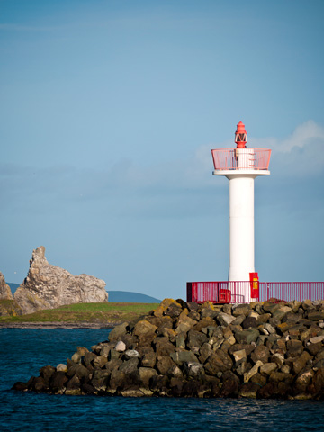 A lighthouse on rocky terrain in Howth, Ireland