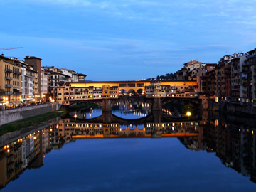 Ponte Vecchio and surrounding buildings reflected in the Arno river in Florence, Italy.