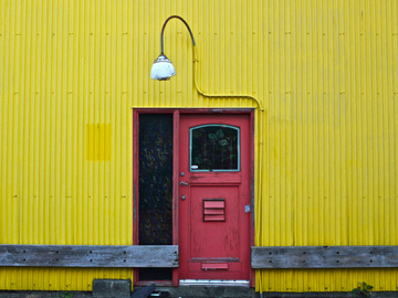 A red door on a yellow wall on Granville Island in Vancouver, Canada