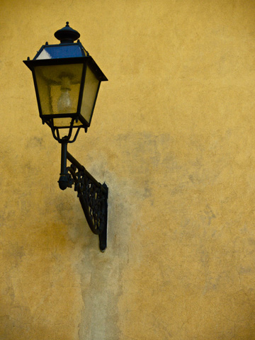 A lamp on a yellow wall in the Boboli Gardens in Florence, Italy
