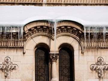 Snow and icicles over a church window