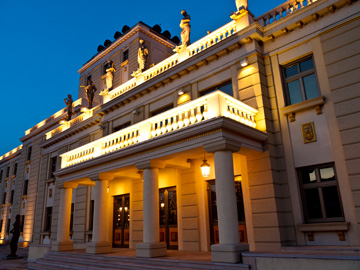 The National Theater illuminated at night in Skopje, Macedonia