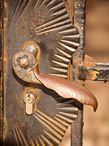 A rusted handle and lock of an old, rusted gate