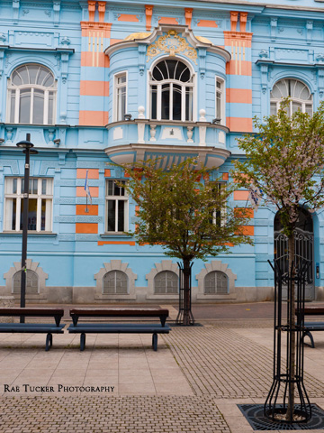 A pedestrian street with a blue building in Ceske Budejovice, Czechia.