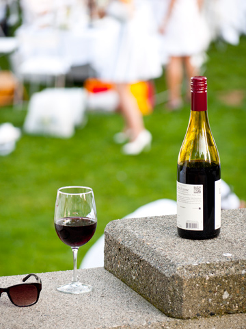 Sunglasses, glass of wine and a wine bottle