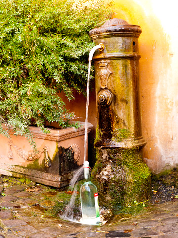 A fountin Rome, Italy fills a glass bottle