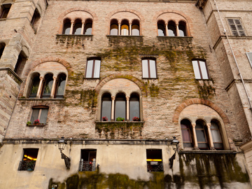 Arched windows look over a piazza in Parma, Italy
