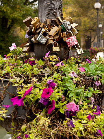 Love locks and flowers adorn a lamppost in Parma, Italy.