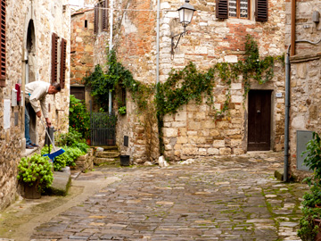 A man sweeps outside of his home in Montefioralle, Italy.