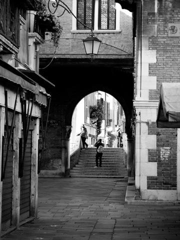 A black and white image in Venice, Italy shows friends photographing one another