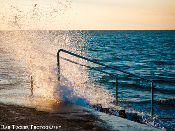 Waves crash under the light of the setting sun