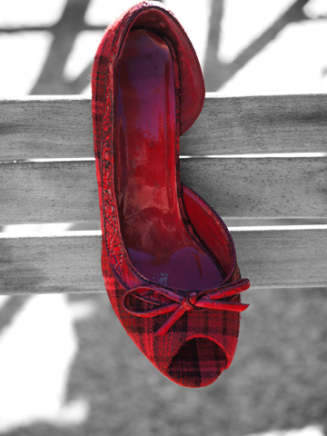 A plaid, red slipper shoe on a black and white background