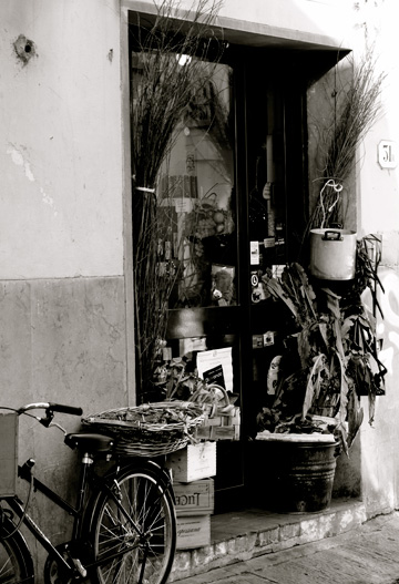 A gourmet food shop in Florence, Italy is decorated by a bicycle and various goods.